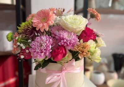 Box de fleurs fraîches pastel avec roses chrysanthèmes et ruban rose