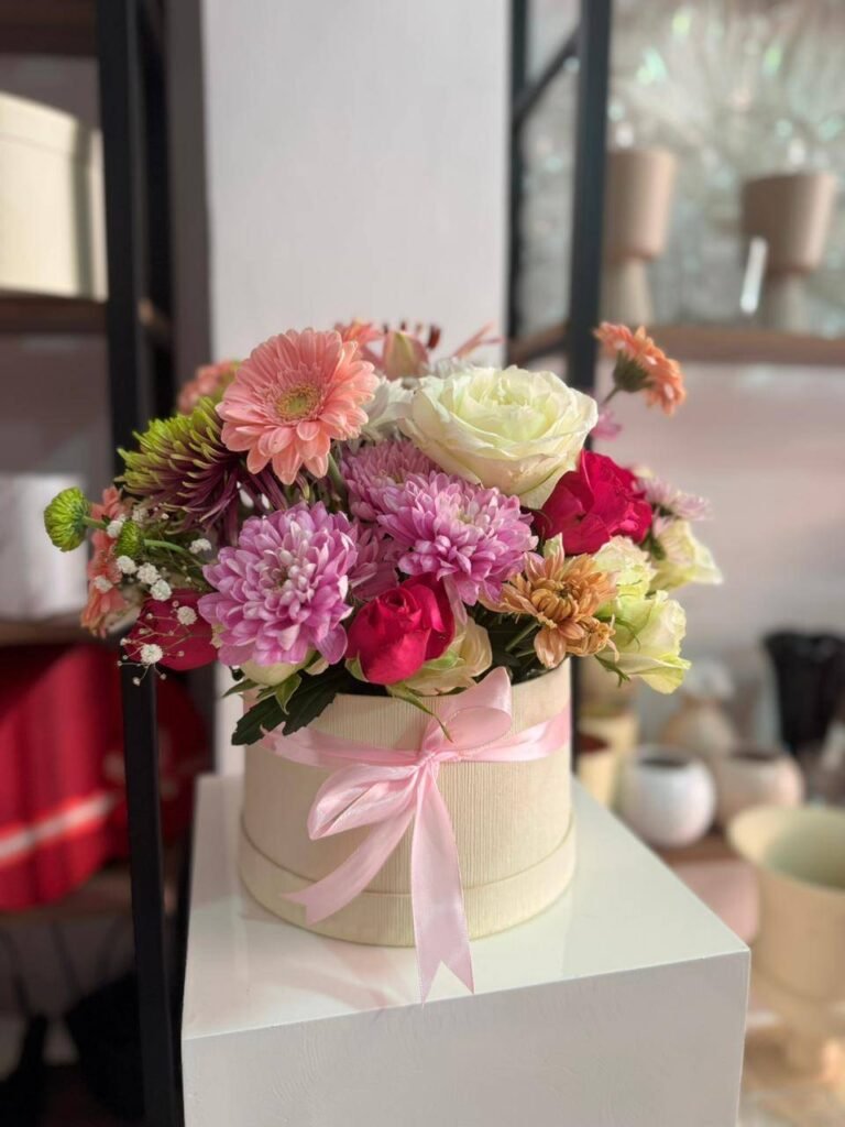 Box de fleurs fraîches pastel avec roses chrysanthèmes et ruban rose